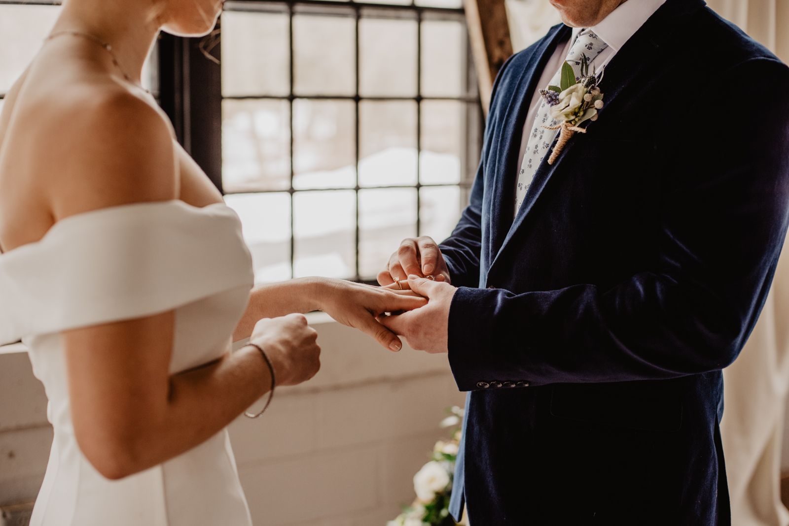 A groom handing over a wedding ring